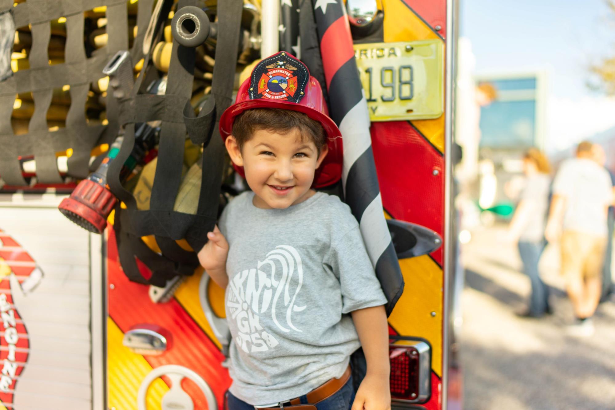 Kid in front of a firetruck