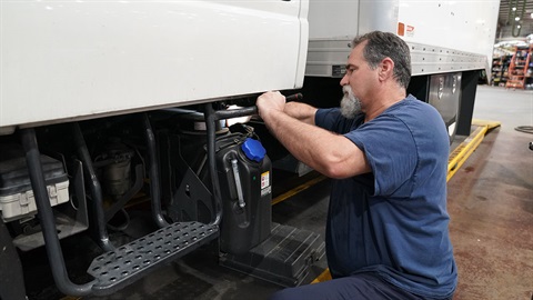 This is a photograph of a Clearwater fleet mechanic working on a truck