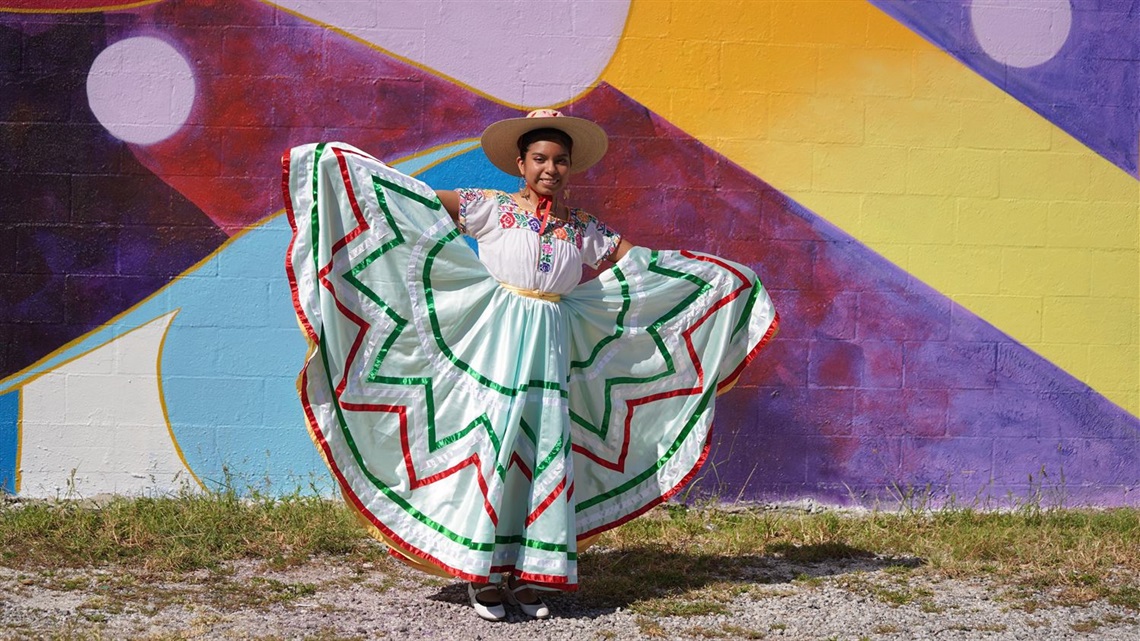 girl holding dress to display colors